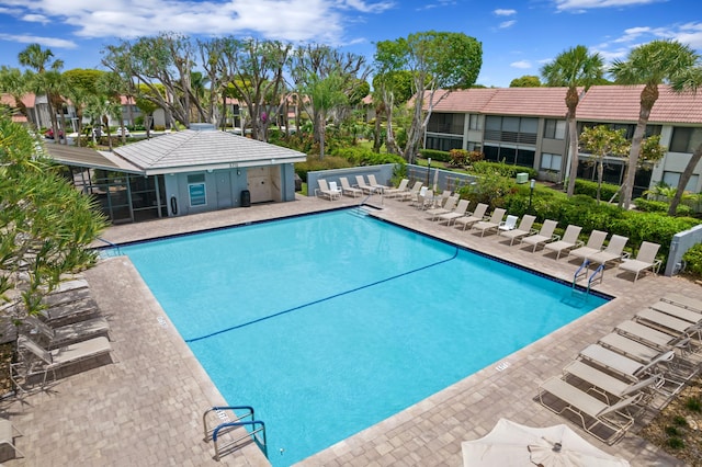 pool featuring a patio, fence, and a residential view
