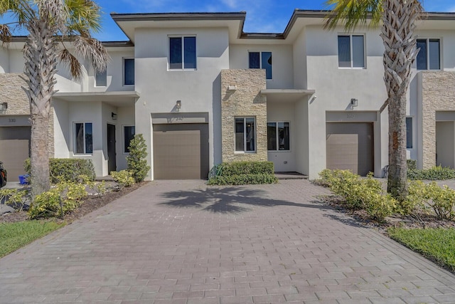340 Pioneer Way, Royal Palm Beach, FL 33411 - view of front of property with an attached garage, decorative driveway, stucco siding, and stone siding