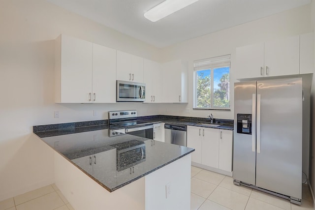 340 Pioneer Way, Royal Palm Beach, FL 33411 - kitchen featuring stainless steel appliances, dark stone countertops, light tile patterned floors, and a peninsula