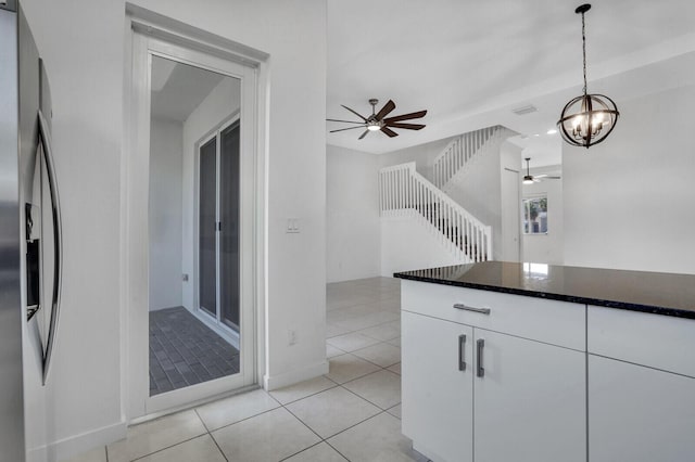 340 Pioneer Way, Royal Palm Beach, FL 33411 - kitchen featuring light tile patterned flooring, dark countertops, stainless steel fridge, ceiling fan with notable chandelier, and white cabinetry