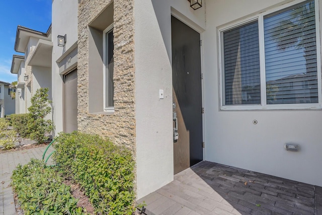 340 Pioneer Way, Royal Palm Beach, FL 33411 - doorway to property featuring stucco siding and stone siding