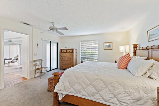 bedroom with carpet flooring, a ceiling fan, a closet, and a textured ceiling