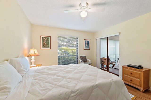 bedroom with light wood finished floors, a textured ceiling, a closet, and a ceiling fan