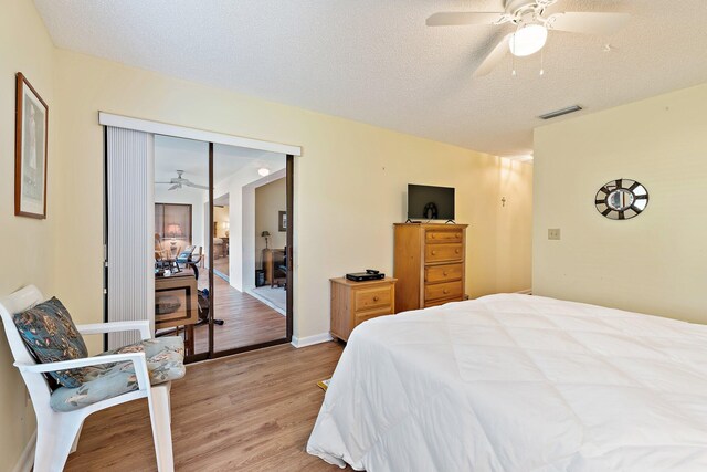 bedroom featuring light wood-style floors, a textured ceiling, a closet, and a ceiling fan