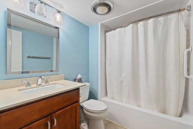bathroom featuring toilet, vanity, tile patterned flooring, and shower / bath combo