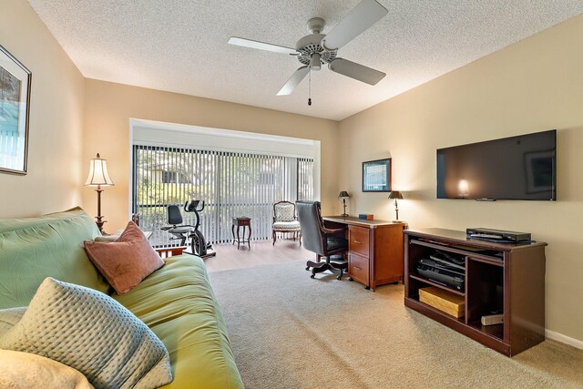 office area with light carpet, a ceiling fan, and a textured ceiling