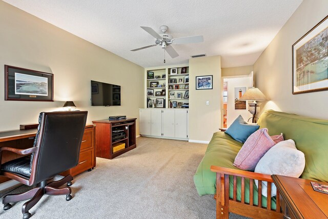 office area with light colored carpet, a ceiling fan, and a textured ceiling