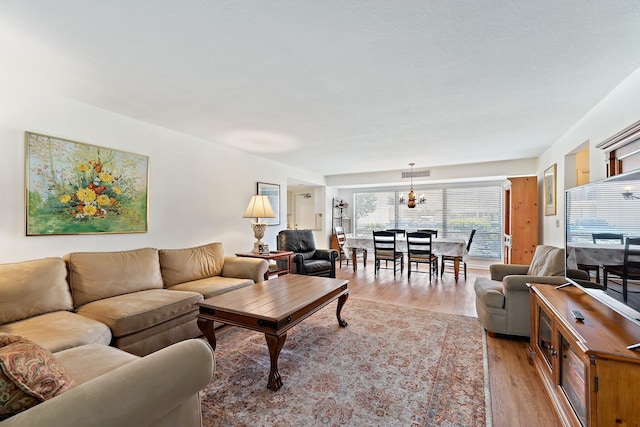 living area featuring a chandelier and light wood-style flooring