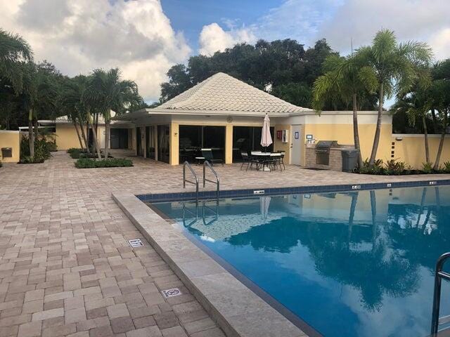 community pool featuring area for grilling and a patio area