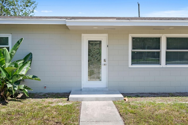 1625 Seaway Dr, Hutchinson Island, FL 34949 - view of exterior entry with concrete block siding and a lawn
