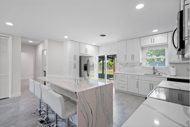 1625 Seaway Dr, Hutchinson Island, FL 34949 - kitchen featuring stainless steel appliances, a sink, a kitchen breakfast bar, recessed lighting, and a center island