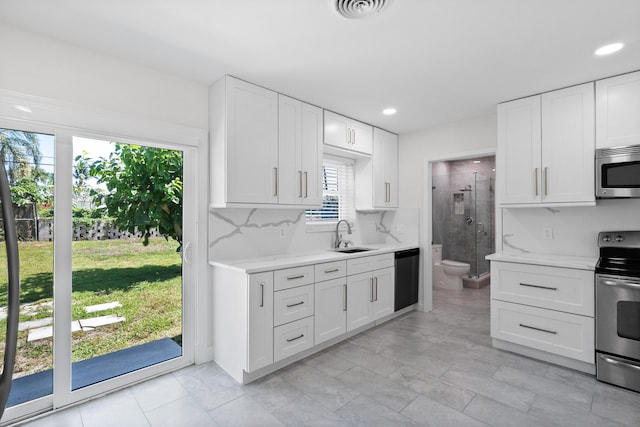 1625 Seaway Dr, Hutchinson Island, FL 34949 - kitchen featuring stainless steel appliances, a sink, white cabinets, recessed lighting, and backsplash