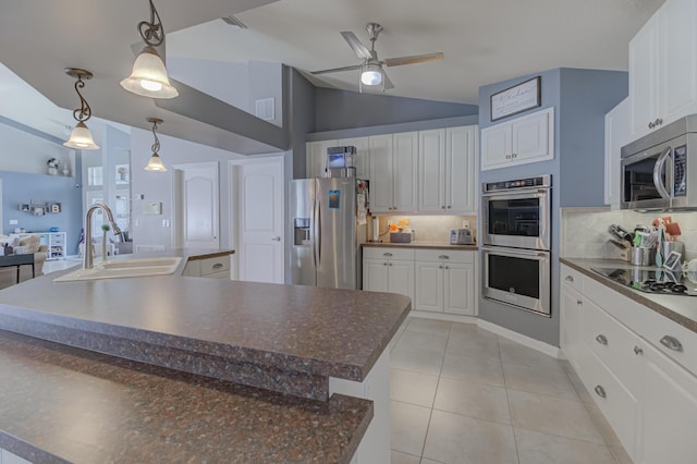kitchen with a sink, lofted ceiling, tasteful backsplash, and stainless steel appliances