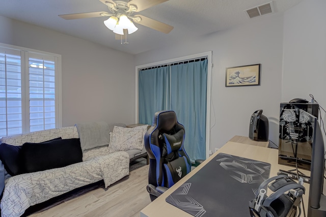 home office featuring visible vents, ceiling fan, and wood finished floors