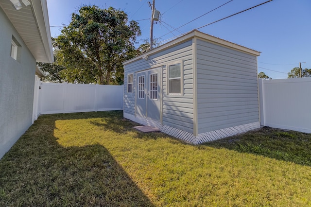 view of outdoor structure featuring a fenced backyard and an outbuilding