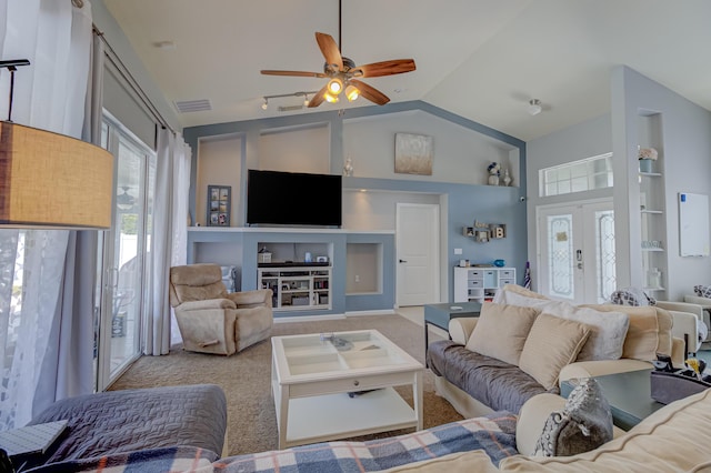 living room with a healthy amount of sunlight, built in features, vaulted ceiling, and visible vents