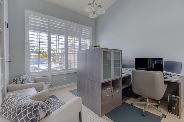 office area with baseboards and vaulted ceiling