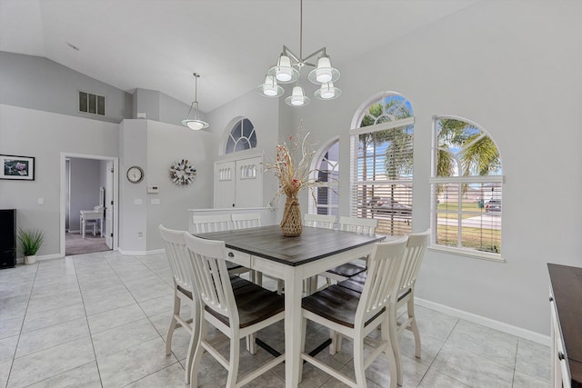 dining space with light tile patterned floors, high vaulted ceiling, a chandelier, and baseboards