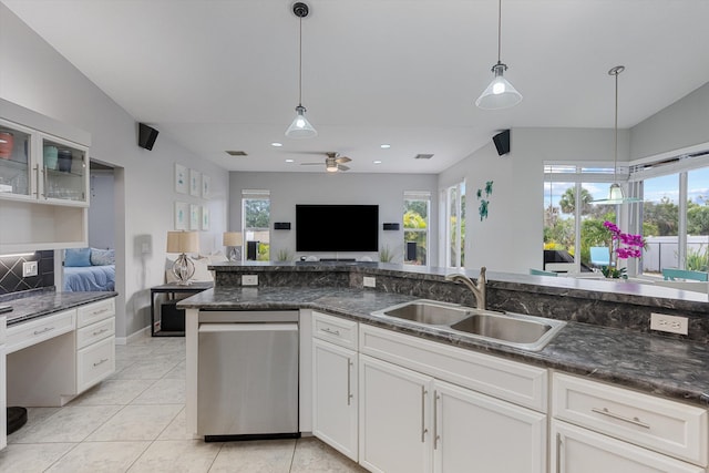 kitchen featuring ceiling fan, stainless steel dishwasher, a sink, open floor plan, and a wealth of natural light