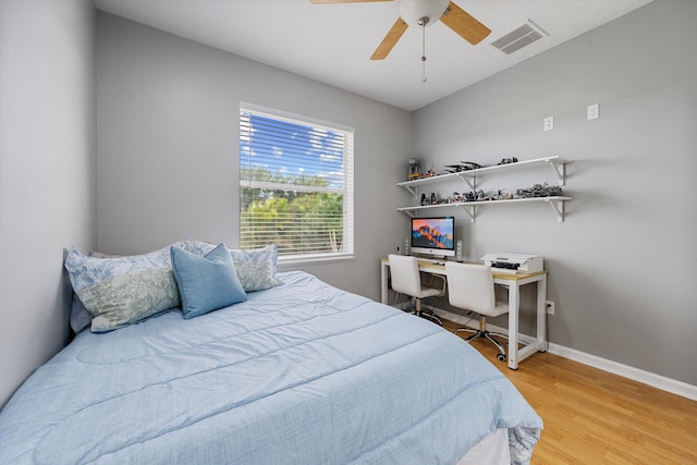 bedroom featuring baseboards, visible vents, ceiling fan, and light wood-style floors