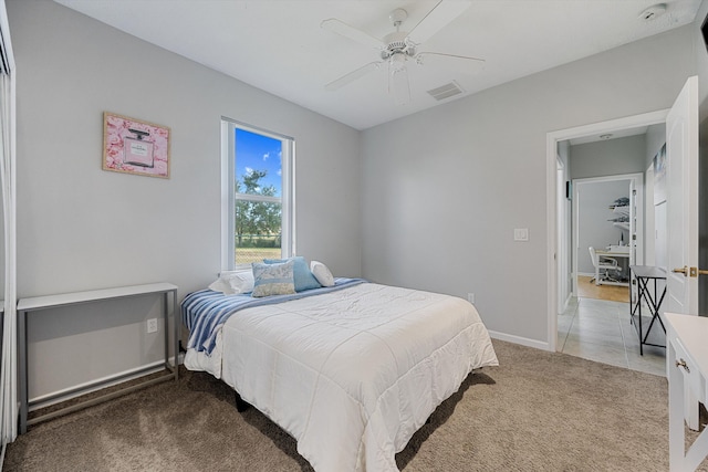 bedroom featuring baseboards, visible vents, ceiling fan, and light colored carpet
