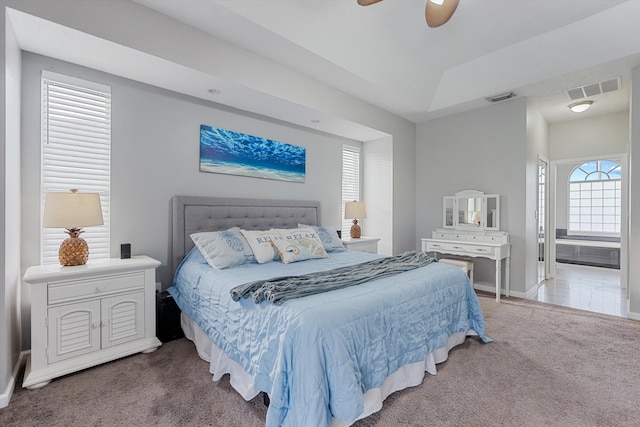 carpeted bedroom featuring visible vents, baseboards, and ensuite bath
