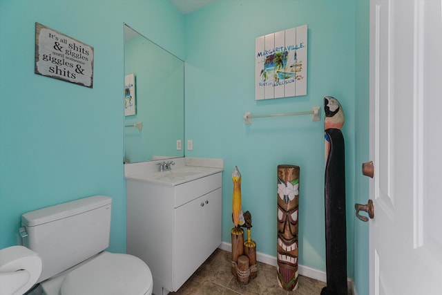 bathroom featuring vanity, baseboards, and toilet