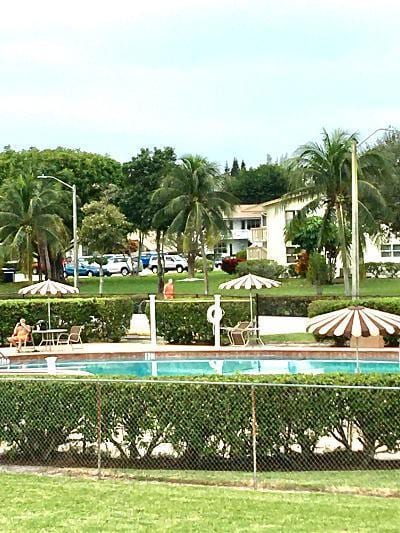 view of property's community with a yard and a swimming pool