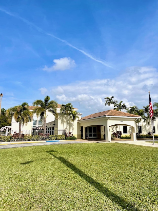 view of front facade featuring fence, a front yard, and stucco siding