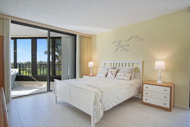bedroom with a textured ceiling, access to exterior, and french doors