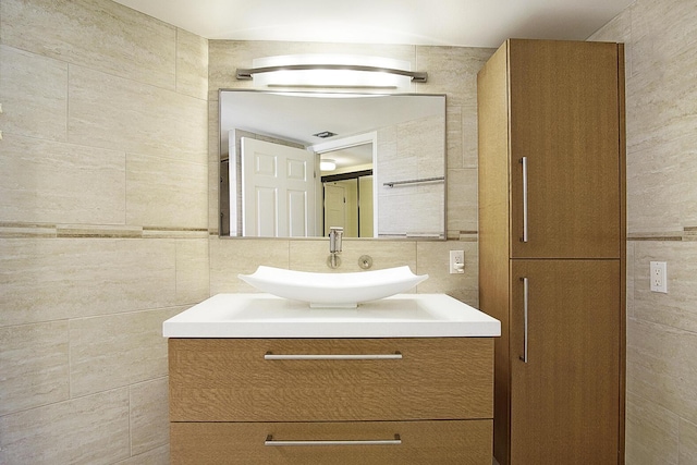 bathroom with vanity and tile walls