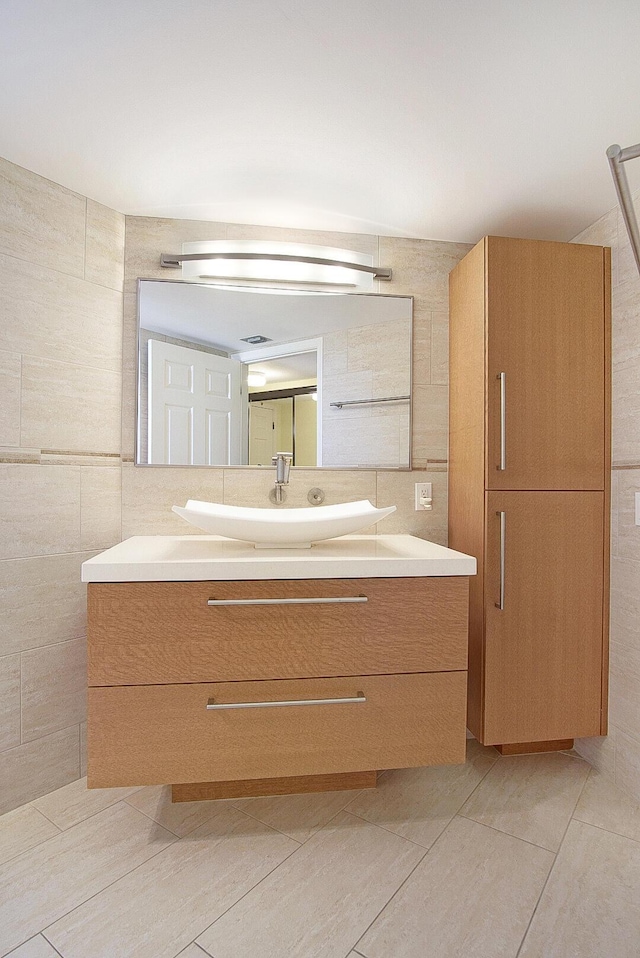 bathroom with vanity, tile patterned floors, and tile walls