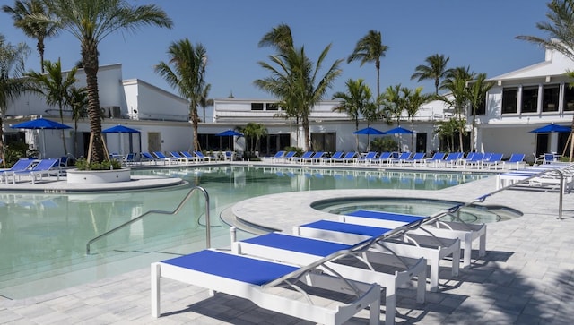 pool featuring a community hot tub and a patio area
