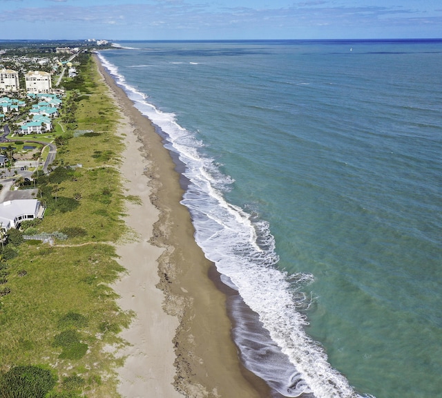 birds eye view of property featuring a water view and a beach view