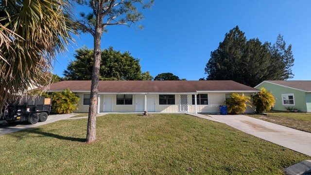 ranch-style house with a porch, driveway, and a front yard