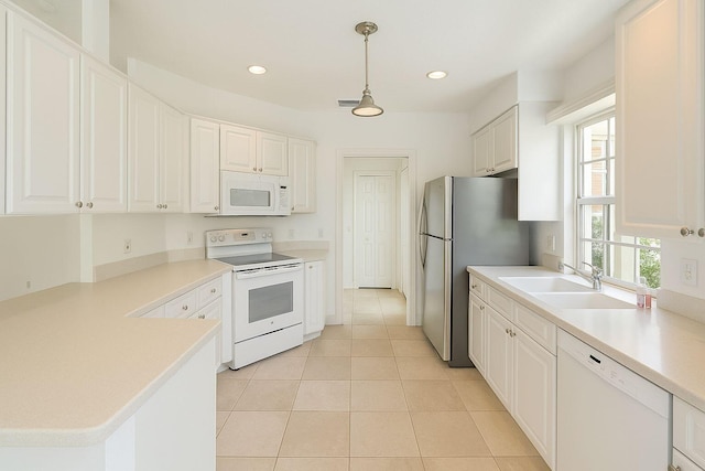 12040 SW Elsinore Dr, Port Saint Lucie, FL 34987 - kitchen featuring white appliances, light countertops, white cabinetry, a sink, and light tile patterned floors