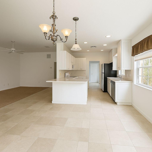 12040 SW Elsinore Dr, Port Saint Lucie, FL 34987 - kitchen featuring appliances with stainless steel finishes, light countertops, ceiling fan with notable chandelier, open floor plan, and baseboards