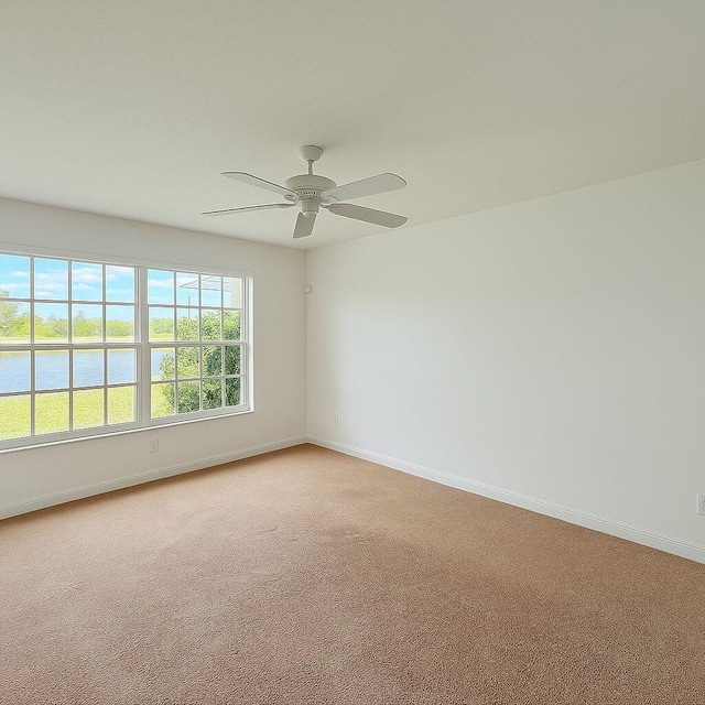 12040 SW Elsinore Dr, Port Saint Lucie, FL 34987 - spare room featuring light colored carpet, baseboards, a water view, and ceiling fan