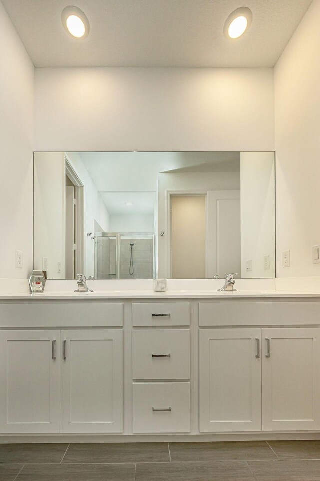 full bath featuring vanity, a stall shower, and wood finish floors