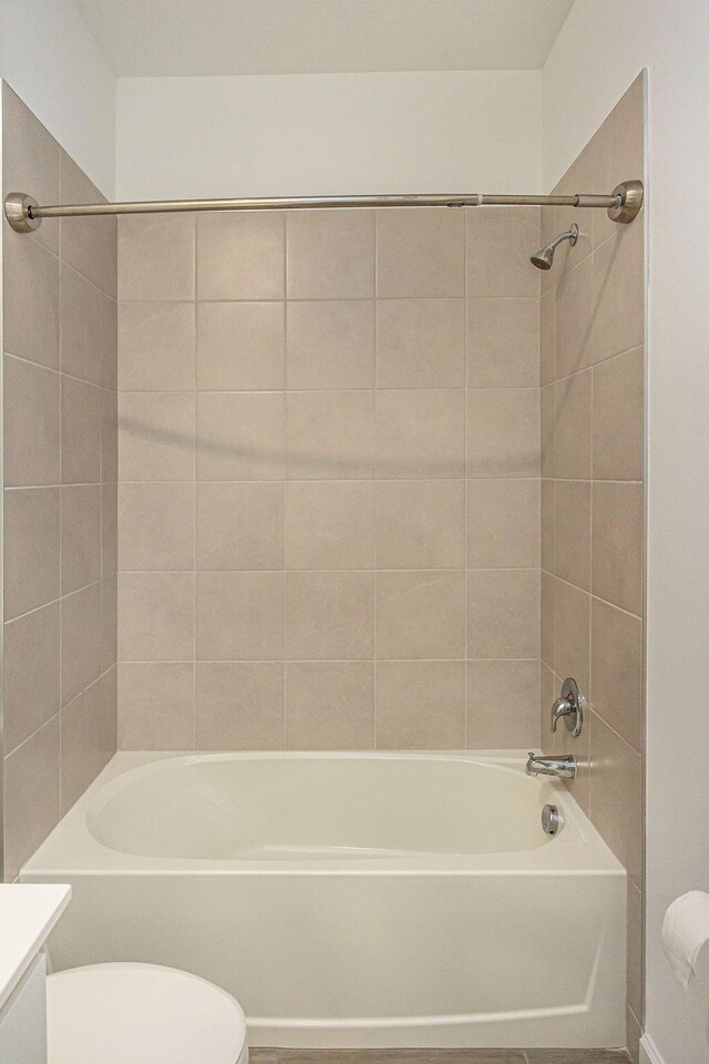 bathroom with shower / bathtub combination, toilet, and vanity
