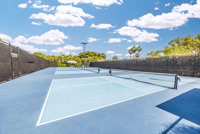 view of tennis court featuring fence