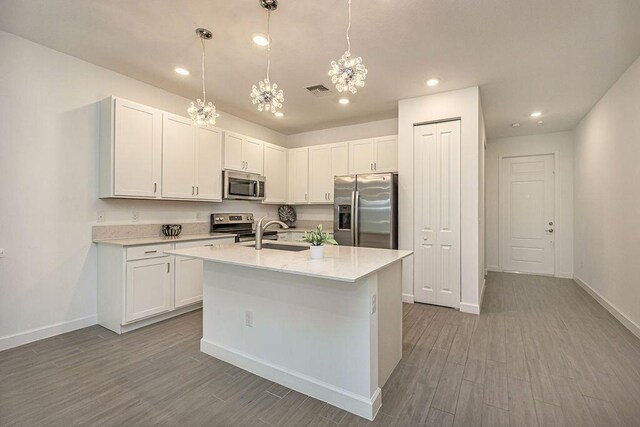 kitchen featuring baseboards, light countertops, wood finished floors, and stainless steel appliances