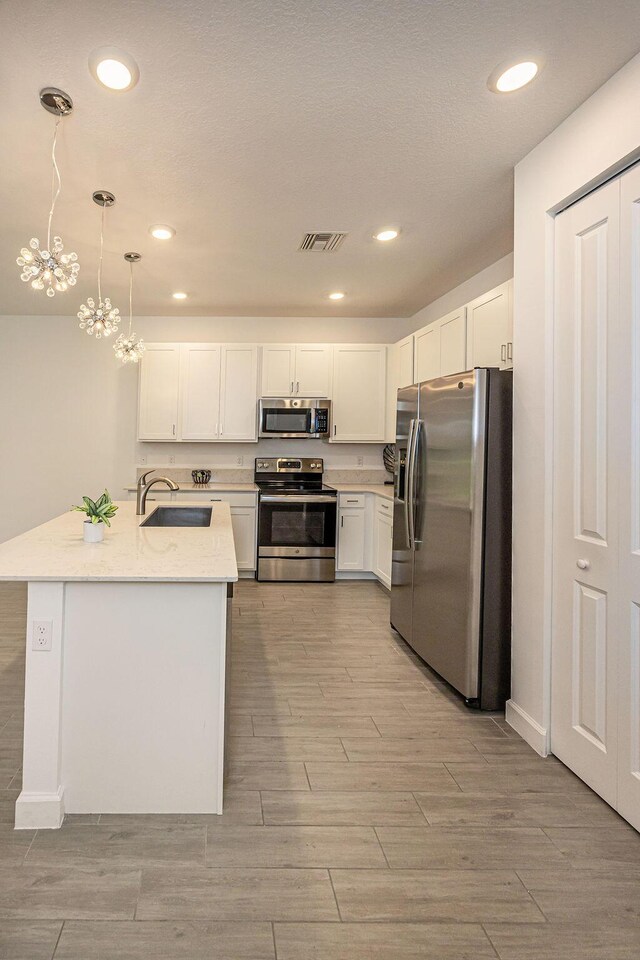kitchen featuring a sink, stainless steel appliances, light wood-type flooring, and visible vents