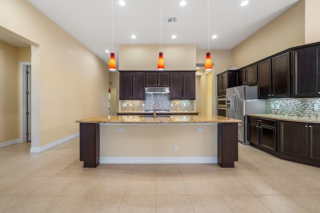 10765 Pisa Rd, Wellington, FL 33414 - kitchen with light stone counters, an island with sink, decorative backsplash, stainless steel refrigerator with ice dispenser, and visible vents