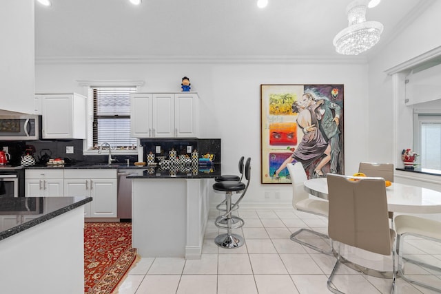 10056 Lexington Cir N, Boynton Beach, FL 33436 - kitchen with crown molding, appliances with stainless steel finishes, white cabinets, and decorative backsplash
