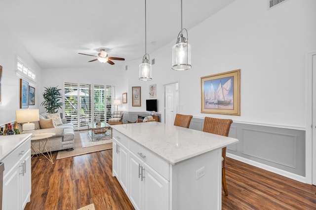 kitchen featuring white cabinets, ceiling fan, open floor plan, dark wood-type flooring, and a kitchen island