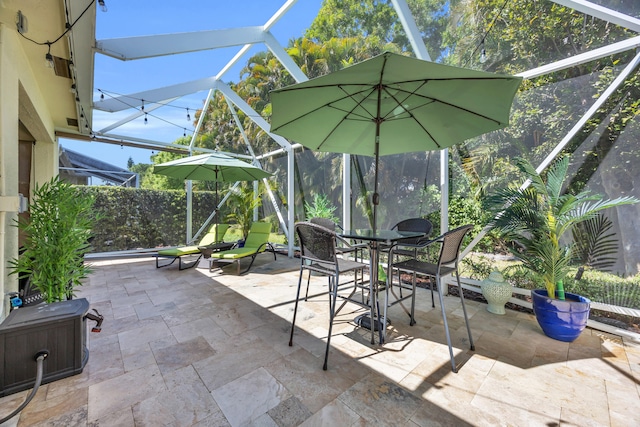 view of patio / terrace featuring outdoor dining area and glass enclosure