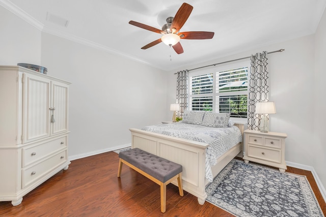 bedroom featuring visible vents, ornamental molding, baseboards, dark wood-type flooring, and a ceiling fan