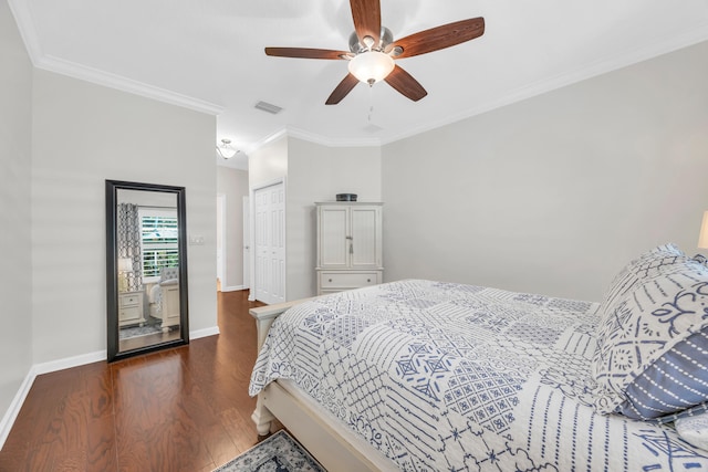 bedroom featuring baseboards, ornamental molding, wood finished floors, and visible vents