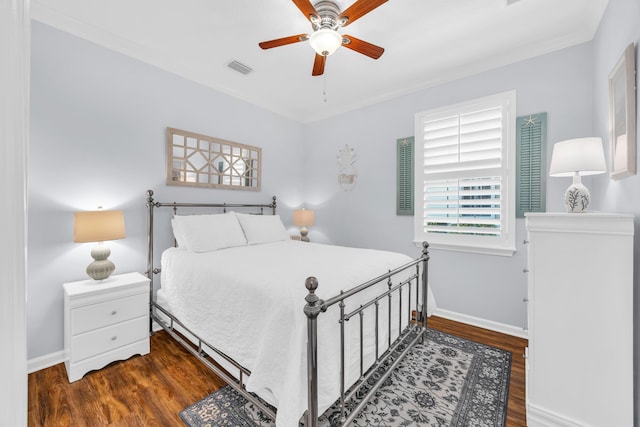 bedroom with crown molding, visible vents, wood finished floors, baseboards, and a ceiling fan